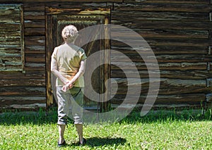 Rear view of a middle aged Caucasian woman standing in front of a a large barn door