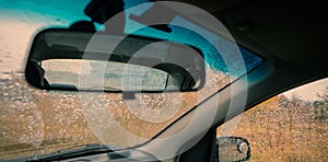 Rear view mirror of a car on a background of glass in drops of a