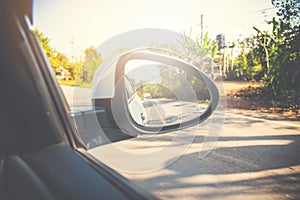 Rear-view mirror car in the reflection forest and long roadway