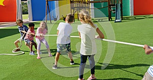 Rear view of mixed-race schoolkids playing tug-of-war in the school playground 4k