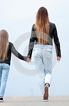 Rear view. mother and daughter step forward