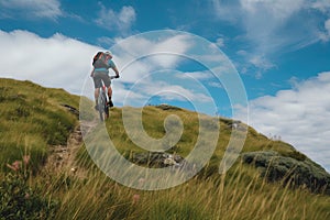 Rear view of a mountain biker cycling on top of a mountain