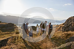 Rear View Of Multi Generation Family Walking On Top Of Hill On Hike Through Countryside In Lake District UK