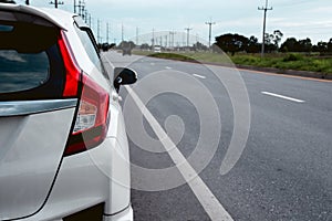 Rear view of new white hatchback car parking on roadside