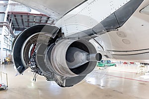 Rear view of the open high-bypass turbofan aircraft engine of a passenger jet plane in a hangar