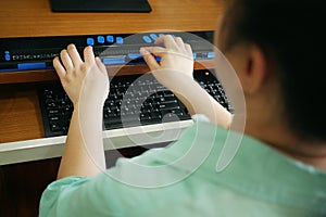 Rear view of person with blindness disability using computer keyboard and braille display or braille terminal a technology
