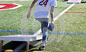 Rear view of a person playing cornhole