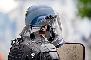 Rear view of police officer wearing gas tear gas mask