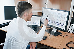 Rear view. Polygraph examiner works in the office with his lie detector`s equipment