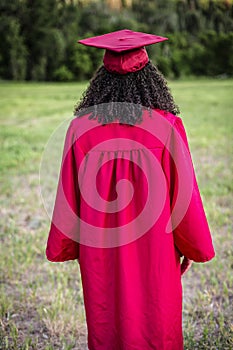 Rear view of beautiful multiethnic woman in her graduation cap and gown photo