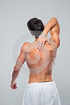 Rear view portrait of a muscular man with neck pain