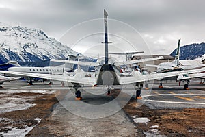 Rear view of private jets, planes and helicopters in the airport of StMoritz Engadin Switzerland in the alps