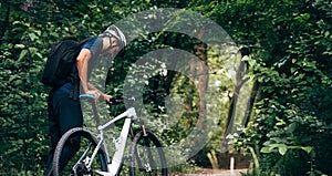 Rear view of professional male cyclist cycling on mountain road on nature background. Male bicyclist riding a bike in the forest