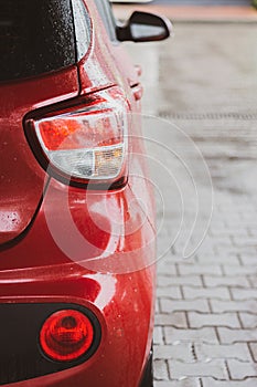 Rear view of red car. Red car on the street. Vehicle part. Rear view of automobile with bacl light. City transportation.