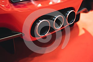 rear view of red sport car triple exhaust pipes