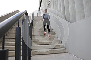 Rear view of runner athlete running on stairs. Woman fitness is jogging oudoors