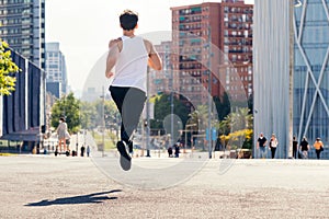 Rear view of a runner running on the asphalt