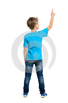 Rear view of a school boy over white background pointing upwards