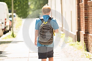 Schoolboy Walking On Sidewalk