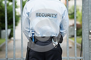 Security Guard Standing In Front Of Gate