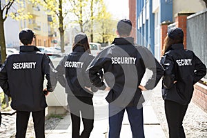 Rear View Of Security Guards Standing In A Row