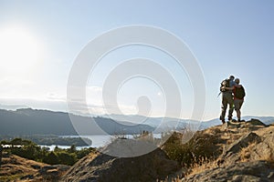 Rear View Of Senior Couple Standing At Top Of Hill On Hike Through Countryside In Lake District UK