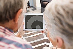 Rear view of senior couple using tablet