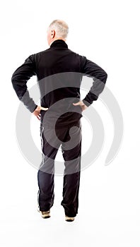 Rear view of a senior man standing with his arms akimbo