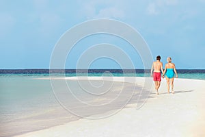 Rear View Of Senior Romantic Couple Walking In Tropical Sea