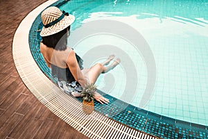 Rear View of Sexy Woman in Swimsuit Relaxing in Swimming Pool, Beautiful Woman Wearing Straw Hat and Relax on The Edge of Poolside