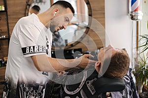 Rear view shot of hairdresser cutting hair of male client. Barber shop