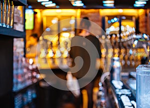 Rear view of the silhouet of bar maid bartender woman in beer wi