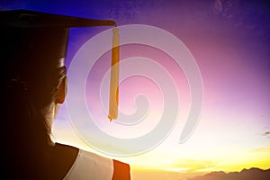 Rear view silhouette of Student  Graduation watching the sunrise