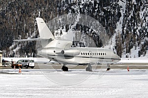 Rear view of a silver color private jet in the alps switzerland in winter