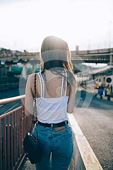 Rear view slender young woman with long dark hair