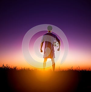 Rear view soccer player watching the sunrise