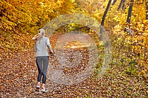 Rear view on sportive woman running in the park