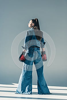 rear view of stylish girl in denim clothes and boxing