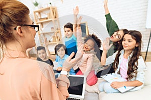 Rear view of teacher who teaches lesson in elementary school. Children`s primary education concept.