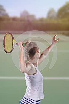 Rear view of tennis player serving during a match