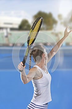 Rear view of tennis player serving during a match