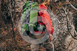 Rear view of traveler bearded male trekking and mountaineering during his journey.