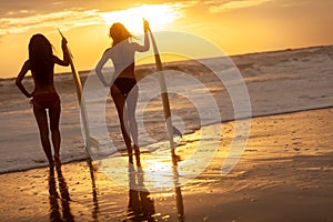 Two Women Bikini Surfers With Surfboard Sunset or Sunrise Beach