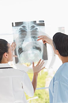 Rear view of two female doctors examining xray