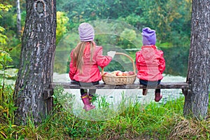 Rear view of two little sisters on bench with