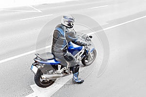 view of unrecognizable man motorbiker wearing protective high-tech suit riding a moder sport motorcycle photo
