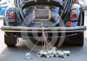 Rear view of a vintage car with just married sign and cans attached photo