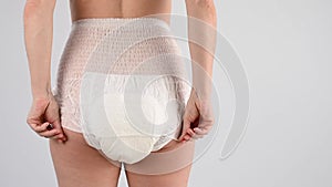 Rear view of a woman in adult diapers. Incontinence problem.