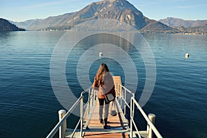 Rear view of a woman alight on Lake Como pier in Italy