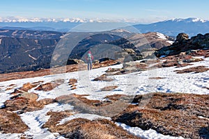 Rear view of woman with backpack hiking on snow covered alpine meadow to Steinerne Hochzeit, Saualpe, Lavanttal Alps photo